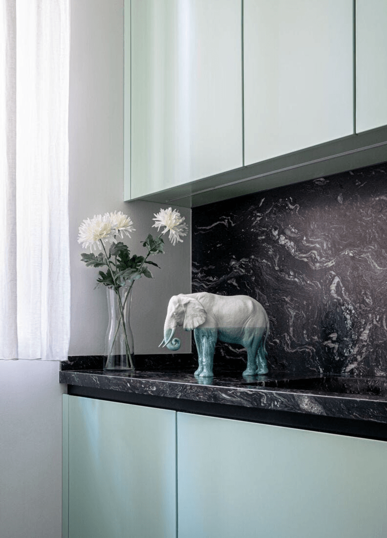 Lladró - Elephant - Underwater Sculpture displayed on a countertop with flowers, highlighting exquisite porcelain craftsmanship.