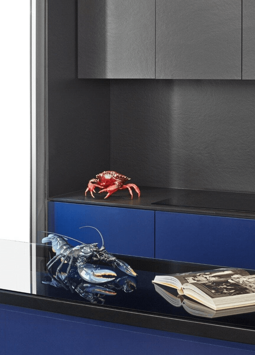 Lladró - Lobster Sculpture - Blue displayed with a red crab on a sleek modern countertop.