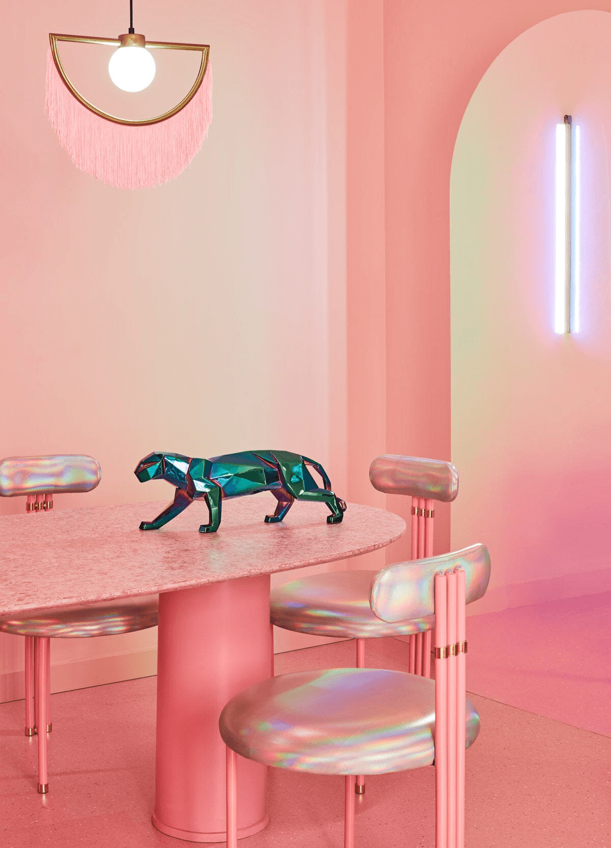 Lladró - Panther Sculpture - Iridiscent displayed on a pink dining table with modern chairs and lighting.