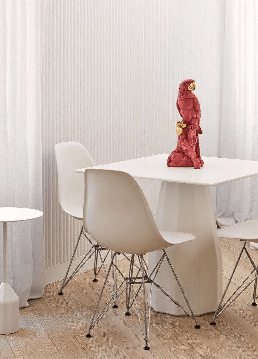 Lladró - Macaw Bird Sculpture - Red-Gold - Limited Edition displayed on a stylish dining table in a modern setting.