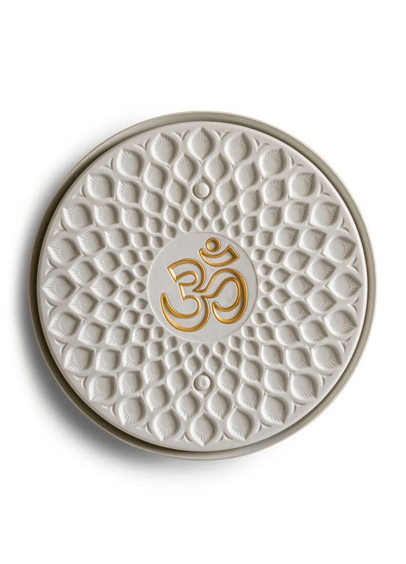 Lladró - Om wall light design featuring a golden 'Om' symbol on a textured white porcelain background.