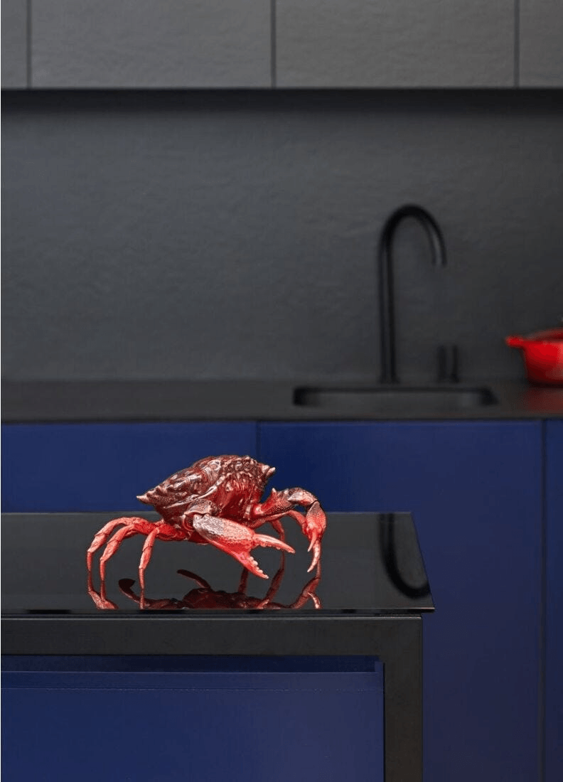 Lladró - Crab Sculpture - Red displayed on a black table in a modern kitchen setting.