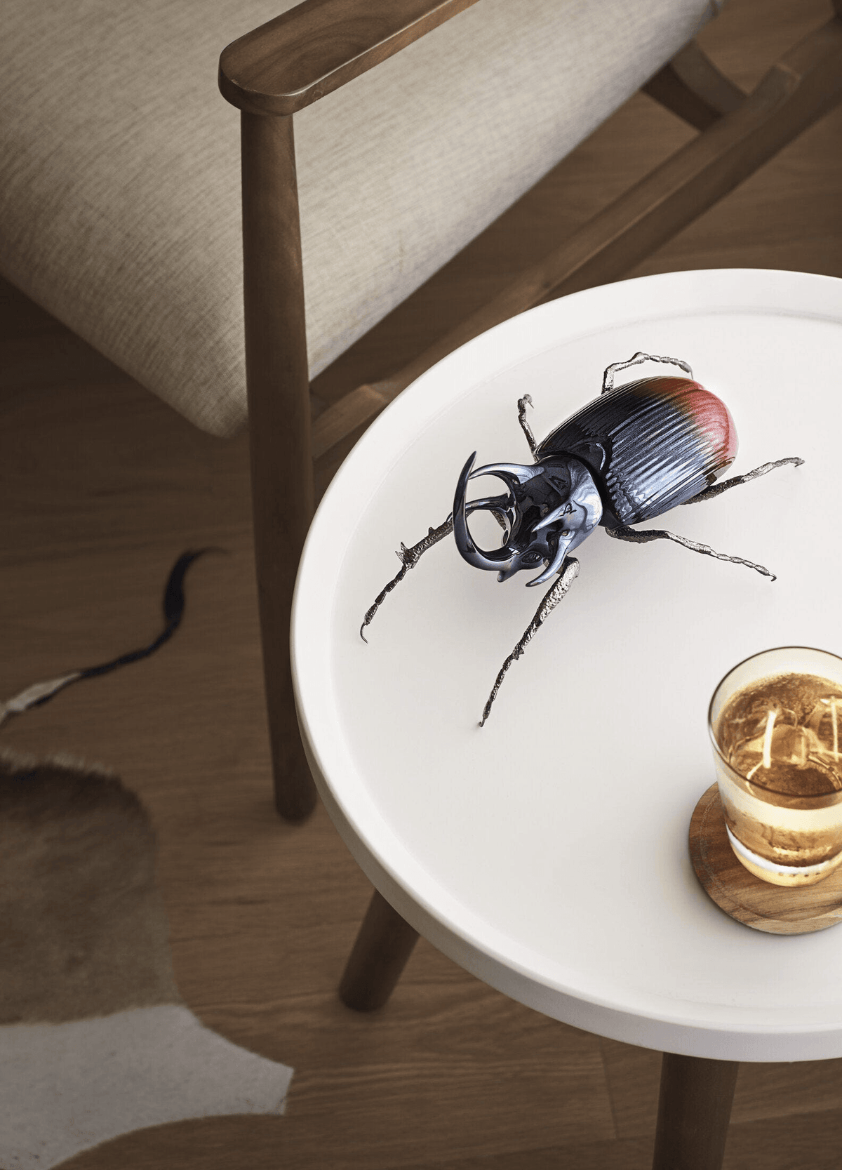 Lladró - Rhinoceros Beetle Figurine displayed on a table, crafted in porcelain with brass legs.