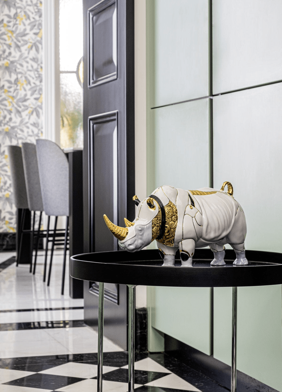 Lladró - Rhino Cyborg Sculpture displayed on a tray in a modern interior setting, featuring porcelain and gold accents.