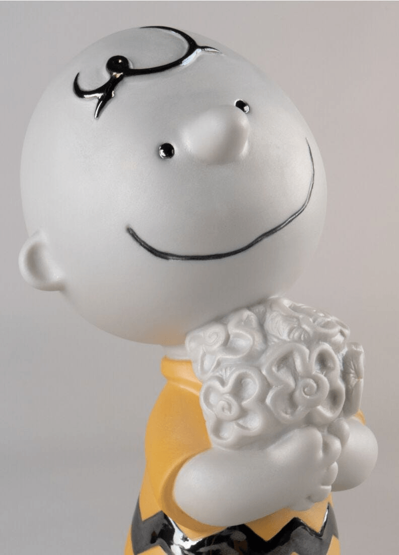 Lladró - Charlie Brown™ Figurine, crafted from porcelain, featuring Charlie Brown holding flowers in a vibrant design.