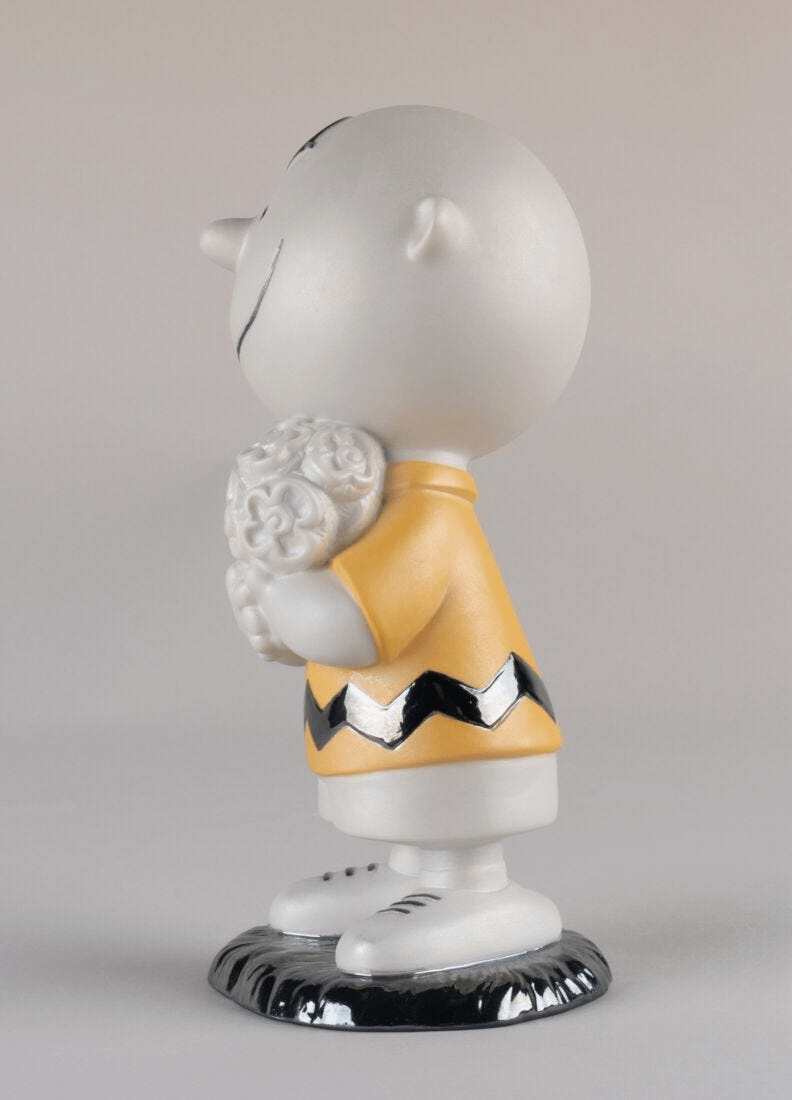 Lladró - Charlie Brown™ Figurine in matte porcelain holding a bouquet of roses, showcasing unique craftsmanship.