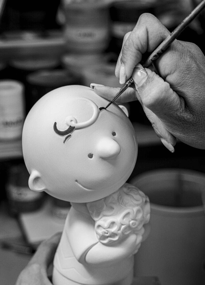 Painting process of Lladró - Charlie Brown™ Figurine, crafted in porcelain.