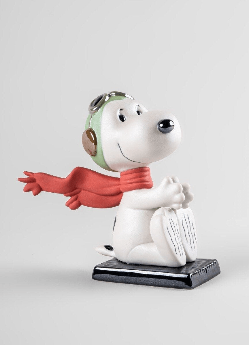 Lladró - Snoopy™ Flying Ace Figurine made of porcelain with a red scarf and green goggles, showcasing Snoopy as a pilot.