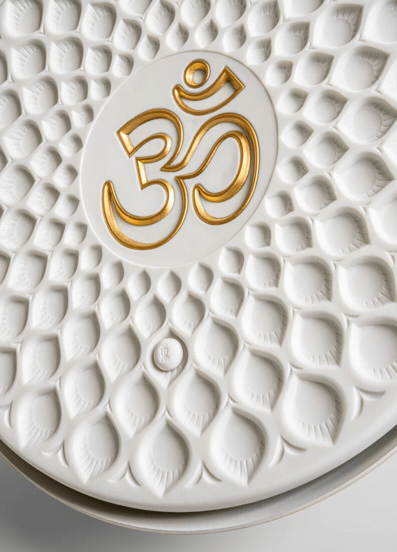 Lladró - Om wall light in porcelain with golden Om symbol, showcasing exquisite design and craftsmanship.