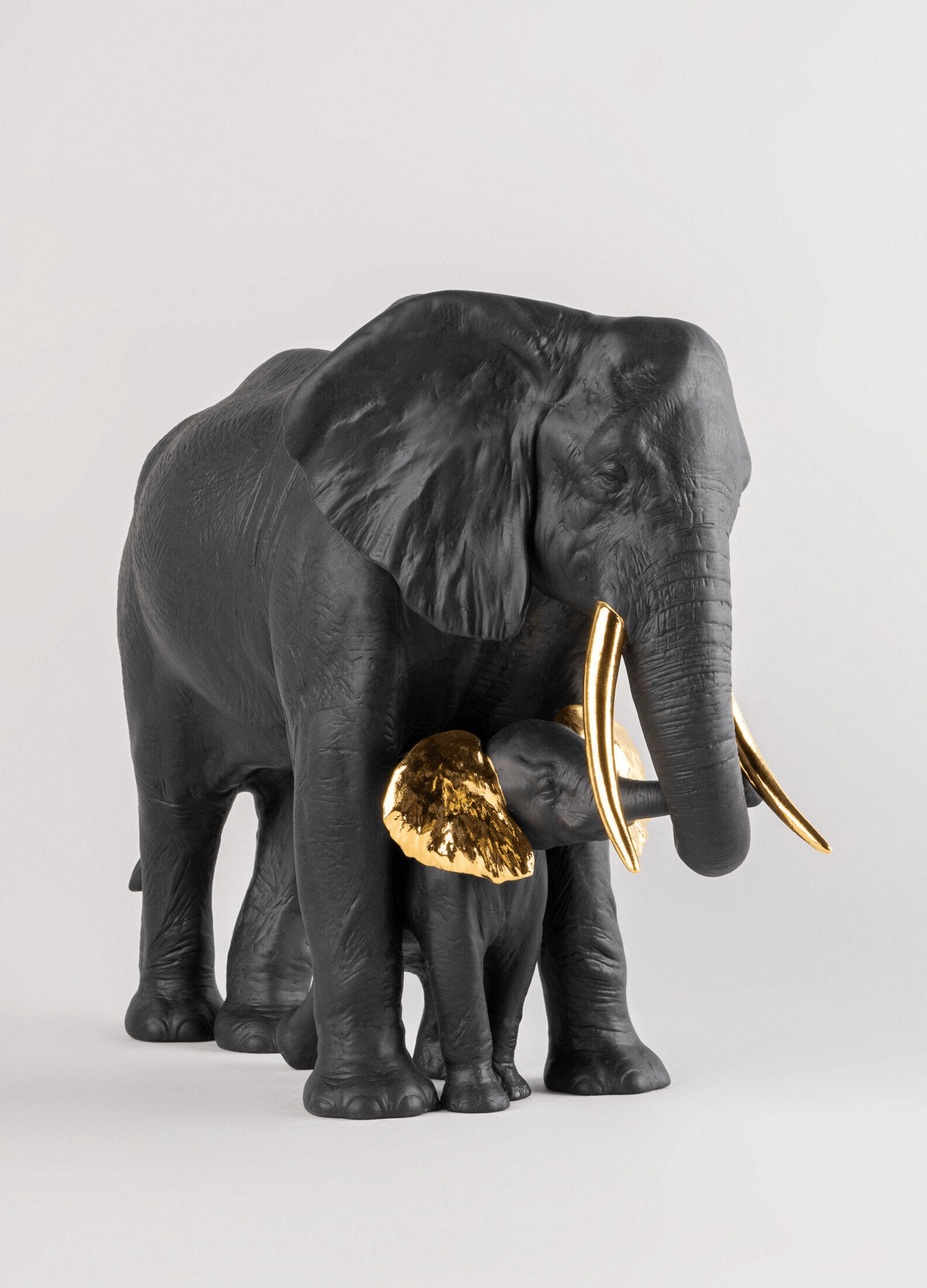 Lladró - Leading the way Sculpture - Black-Gold - Limited Edition featuring a matte porcelain elephant and calf.