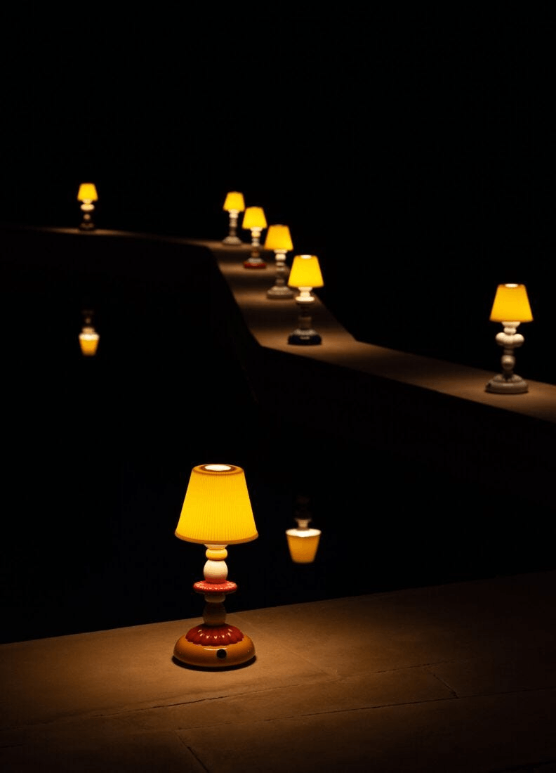 Lladró - Lotus Firefly Table Lamp - Green and Blue, illuminated lamps reflecting in water at night.