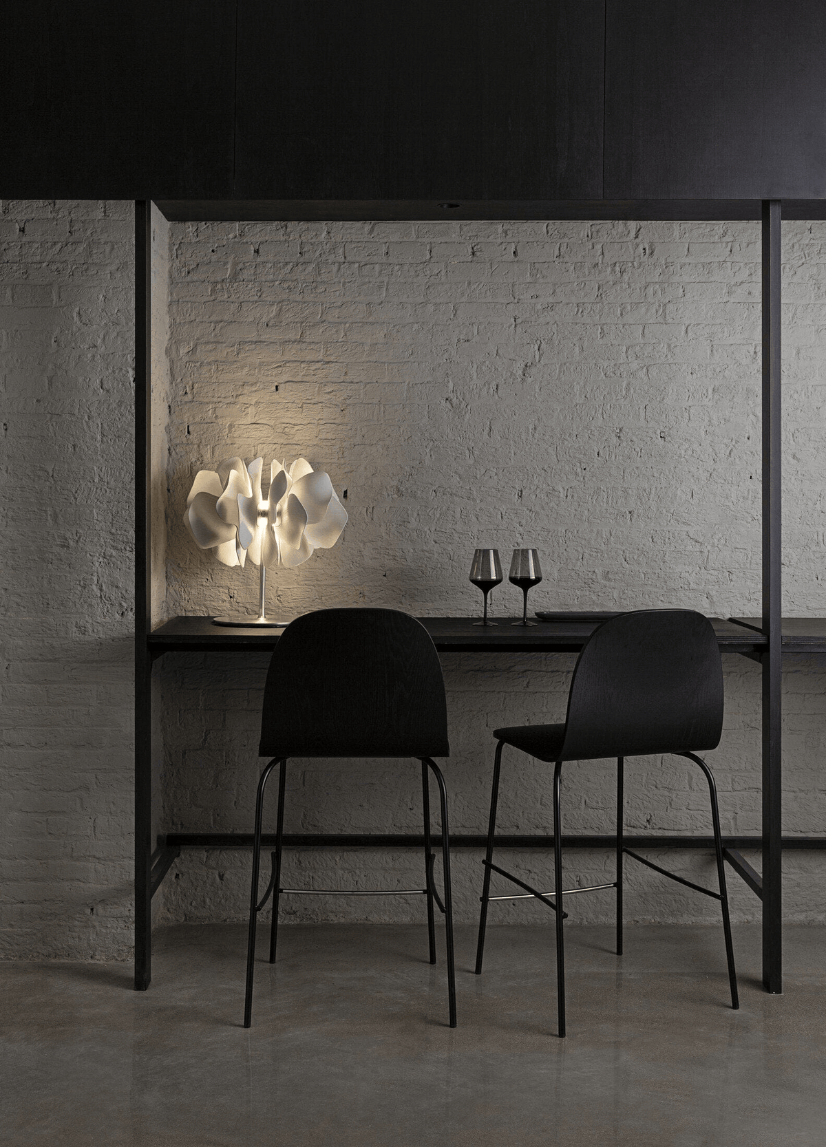 Lladró - Nightbloom Table Lamp - White crafted from Lladro Porcelain, lighting a dark bar table.