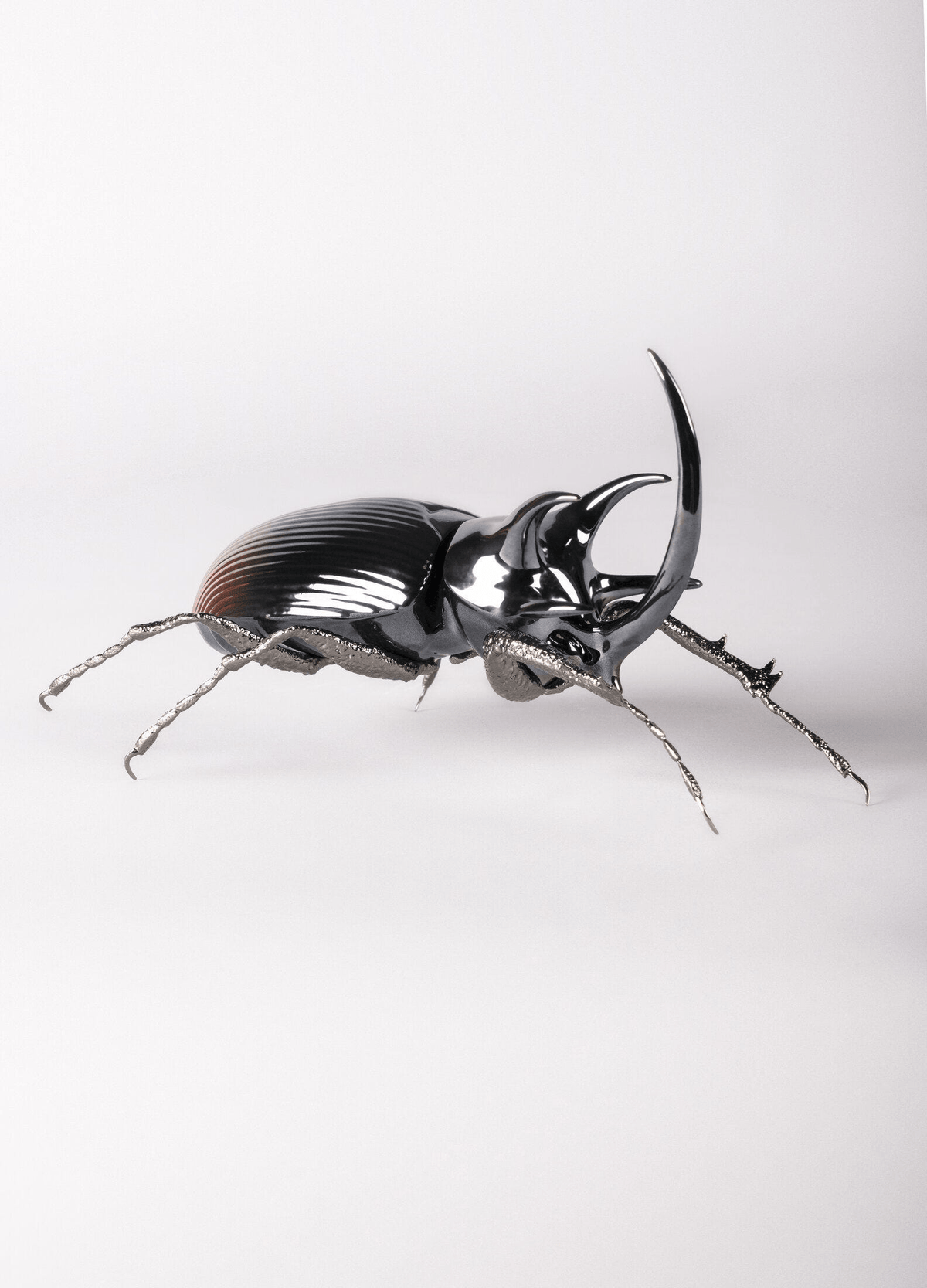 Lladró - Rhinoceros Beetle Figurine in glazed porcelain with brass legs, showcasing exquisite craftsmanship.