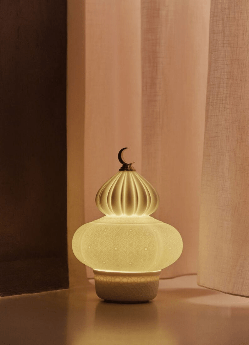 Lladró - Majestic Nights Wireless Lamp glowing warmly, handcrafted porcelain design with intricate latticework.
