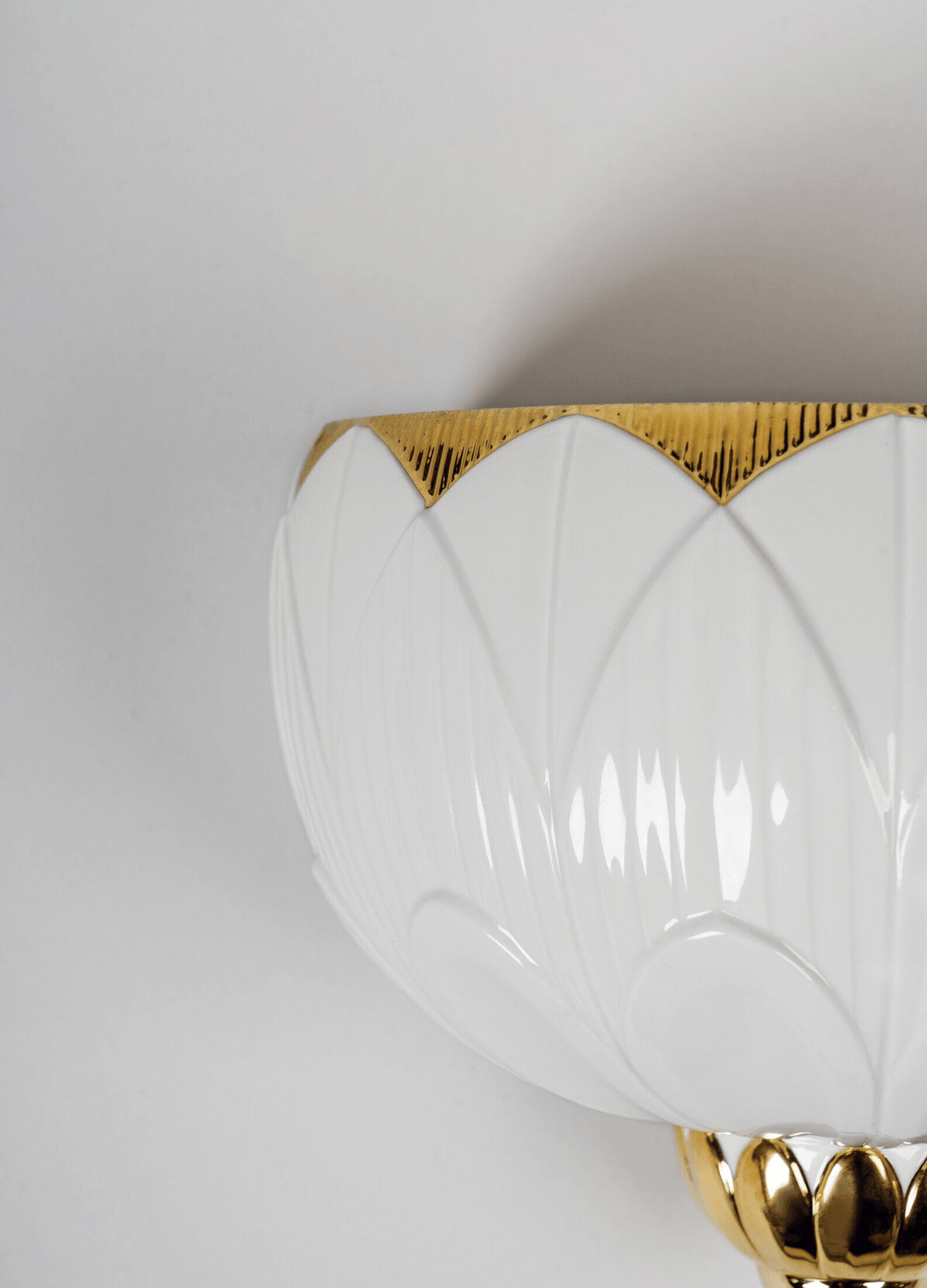 Lladró - Ivy & Seed Wall Sconce featuring elegant porcelain design with gold accents, capturing light beautifully.