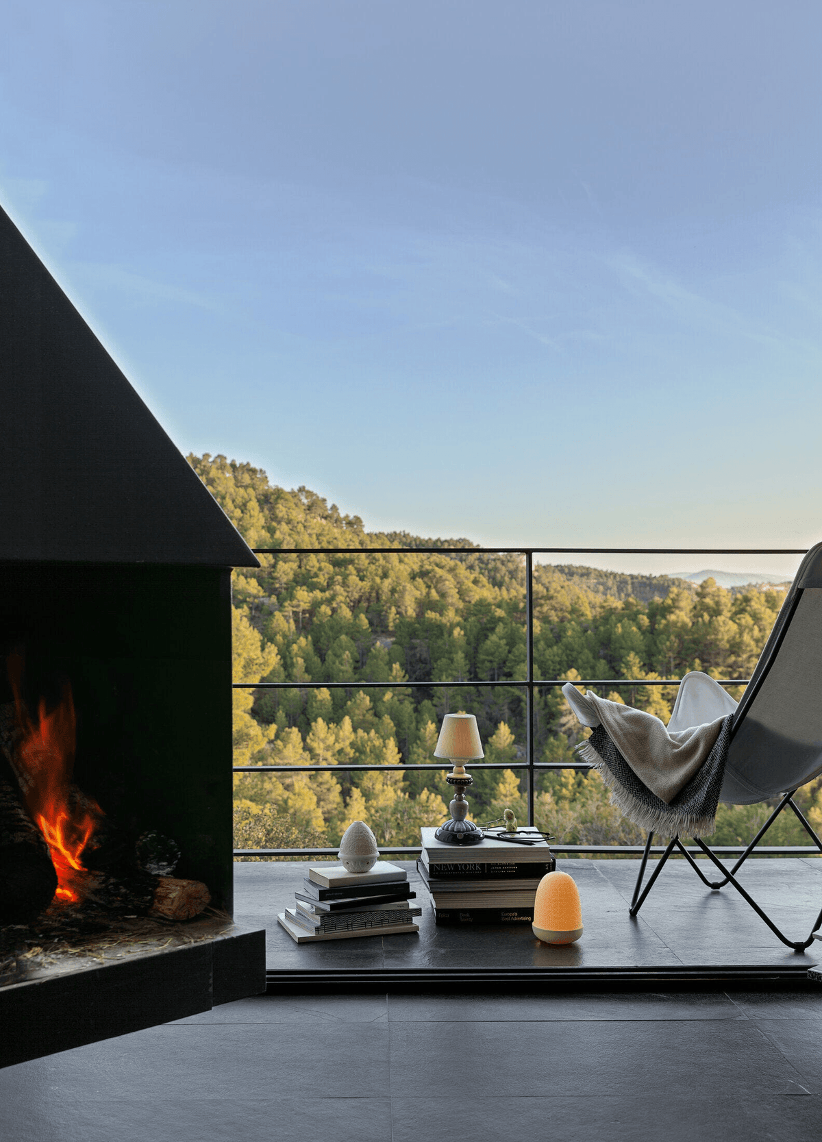 Porcelain Lladro: Lladró - Sunflower Firefly Table Lamp - Ivory glowing on stacked books by a balcony fireplace.