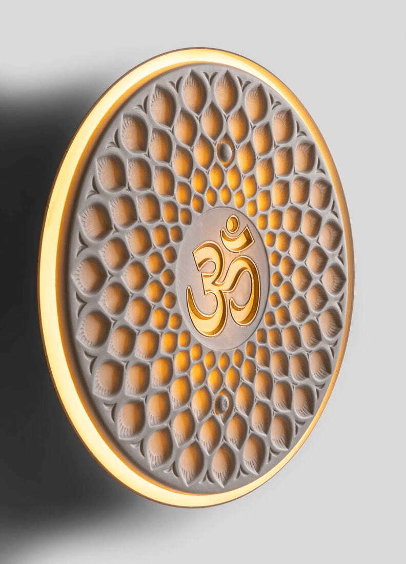 Lladró - Om wall light featuring golden Om symbol on translucent white matte porcelain.