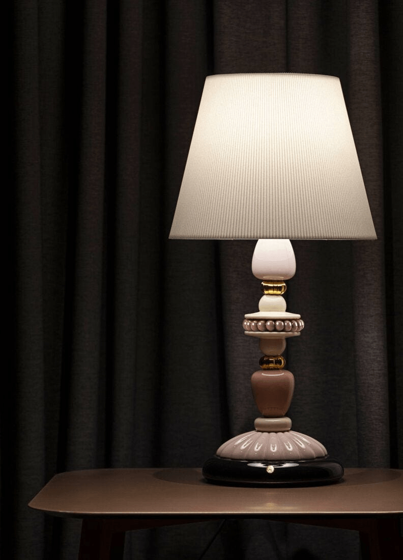 Lladró - Firefly Table Lamp - Pink and Gold on a table with a soft fabric shade, showcasing ornate porcelain design.