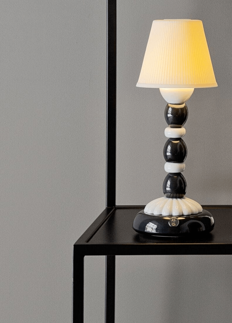 Lladró - Palm Firefly Table Lamp - Black and White on a sleek black table with soft lighting.