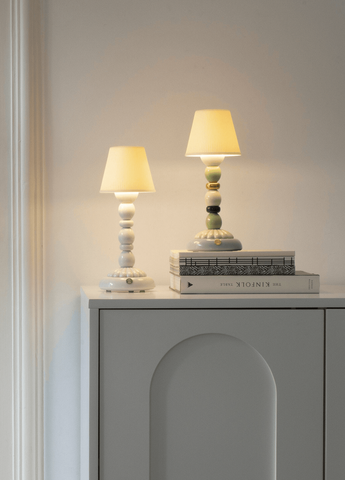 Porcelain Lladro design: Lladró - Palm Firefly Golden Fall Table Lamp - Green and Blue lit on a cabinet.