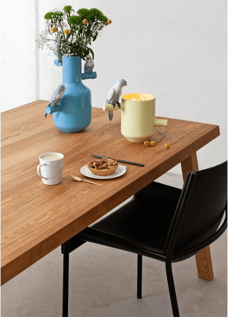 Lladró -Parrot's scented Treasure - On the Prairie Scent - Green displayed on a wooden table with decorative elements.