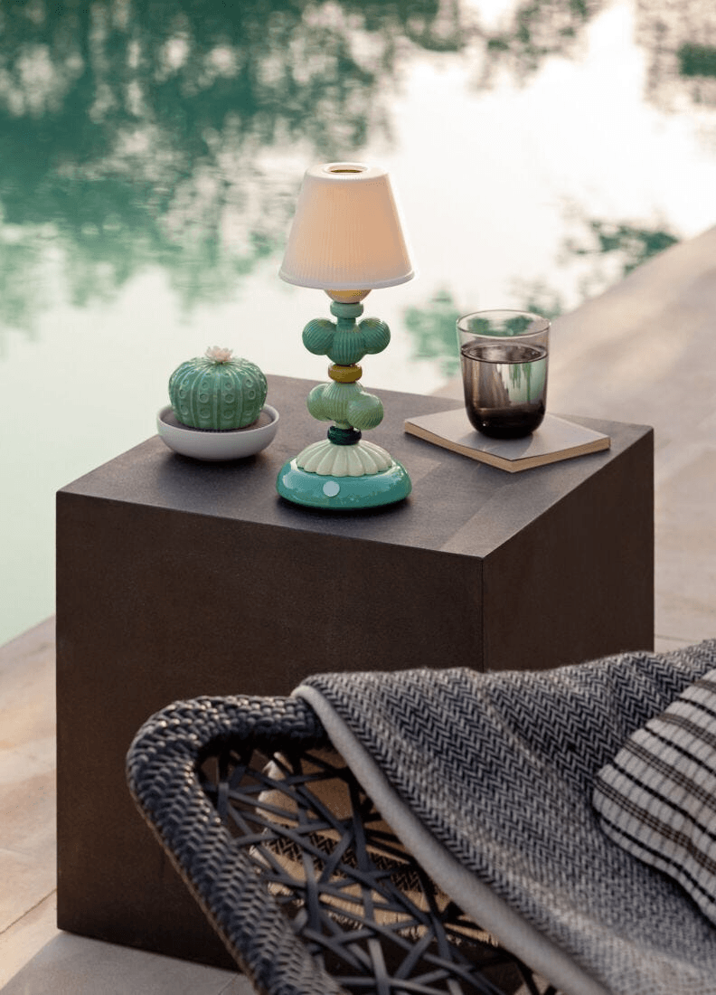 Lladró - Astrophytum Cactus Diffuser - Gardens of Valencia Scent displayed next to a lamp by a pool.