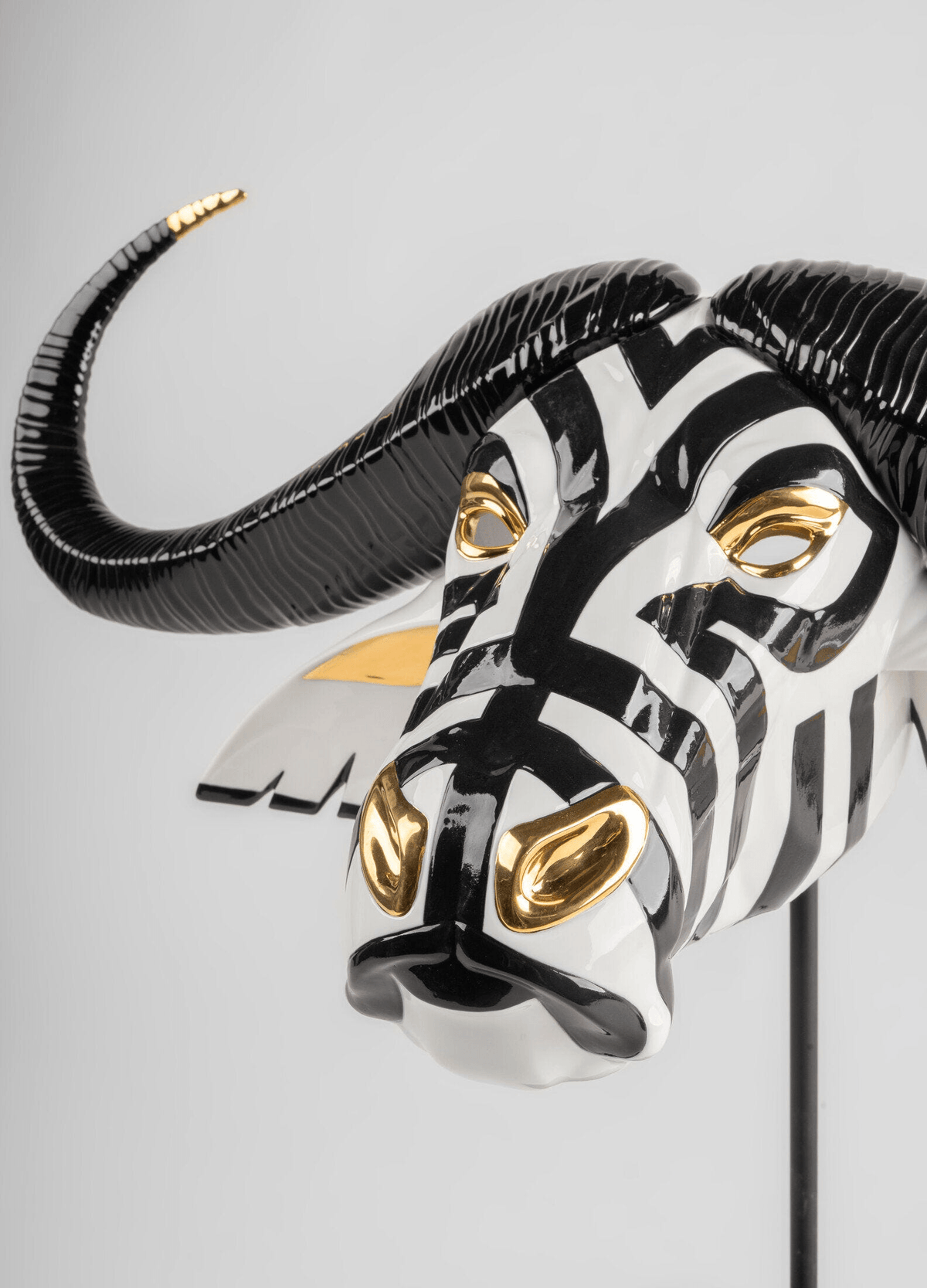 Lladró - Buffalo Mask - Black and Gold, handcrafted porcelain with black and white design and golden accents.