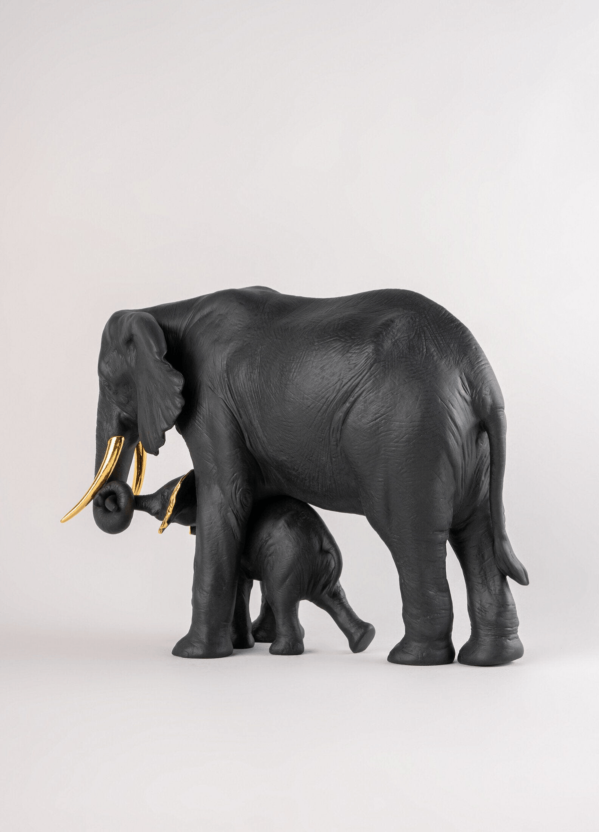 Lladró - Leading the way Sculpture - Black-Gold - Limited Edition, matte porcelain elephant and calf sculpture.