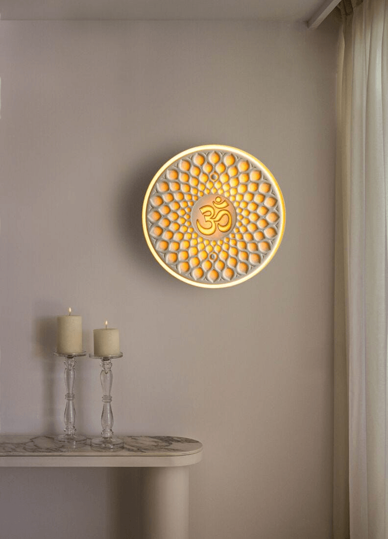 Lladró - Om wall light featuring a golden om symbol in translucent white porcelain, enhancing interior decor.