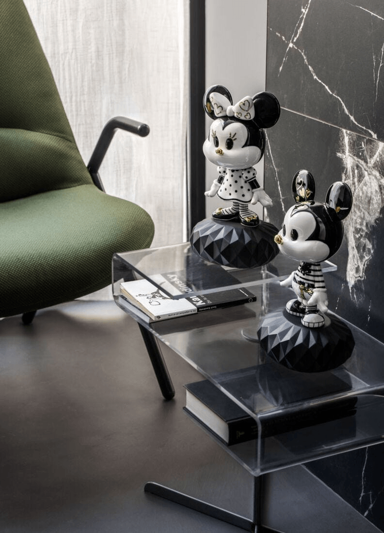 Lladró - Mickey in Black and White Sculpture displayed stylishly on a coffee table next to a green chair.