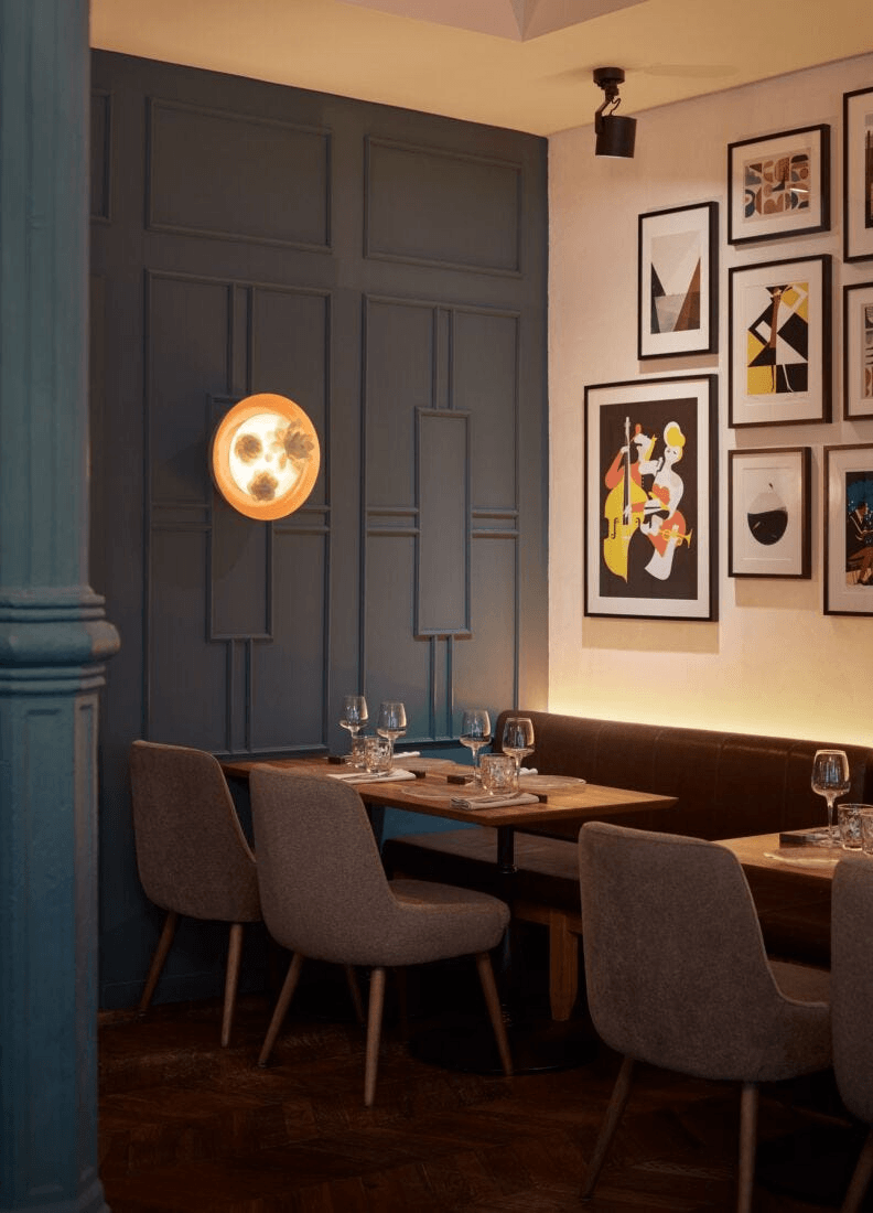 Lladró - Bouquet Wall Sconce illuminating a stylish restaurant interior with contemporary decor.