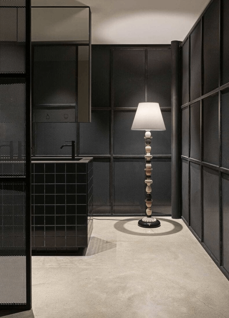 Lladró - Firefly Floor Lamp - Pink and Gold. A Lladro porcelain lamp illuminating a modern industrial space.