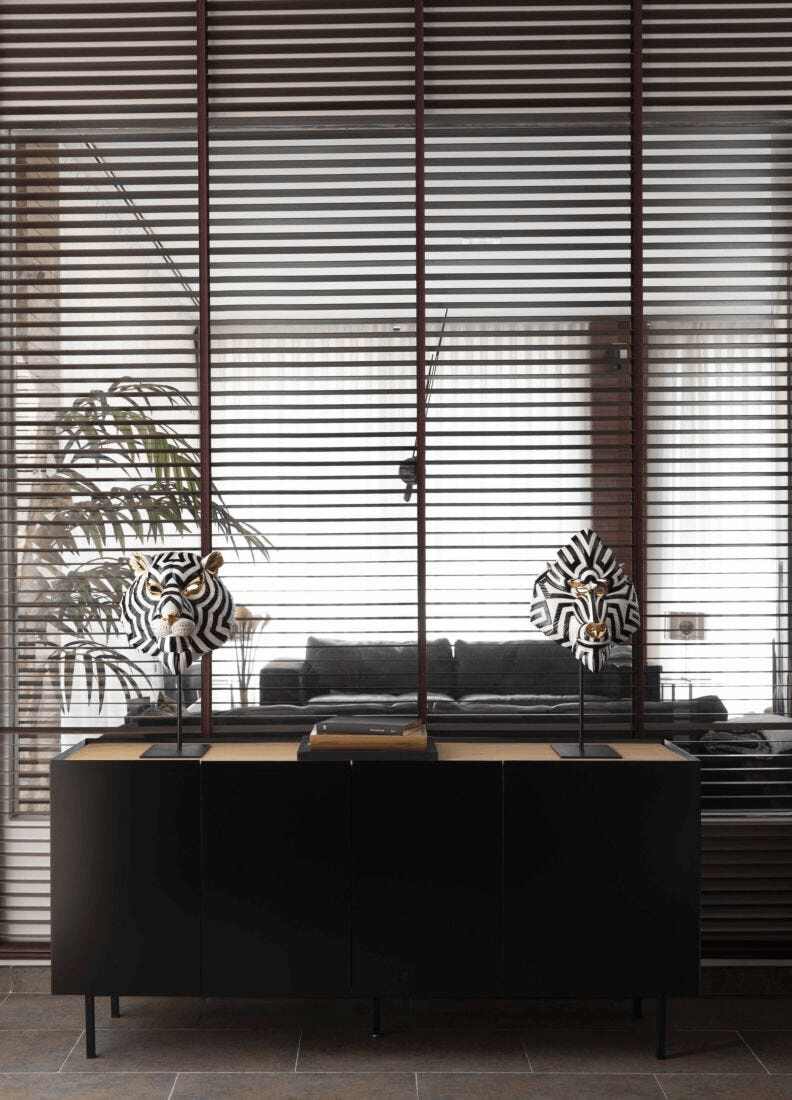 Lladró - Tiger Mask - Black and Gold displayed on a modern black cabinet with wooden top in a stylish interior.