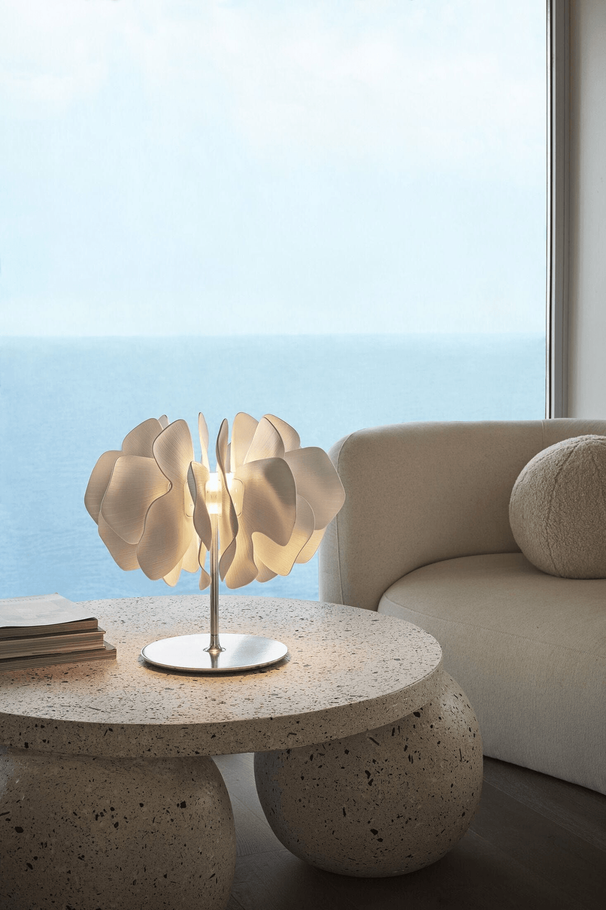 Lladró - Nightbloom Table Lamp - White made of Lladro Porcelain, glowing on a stone table.