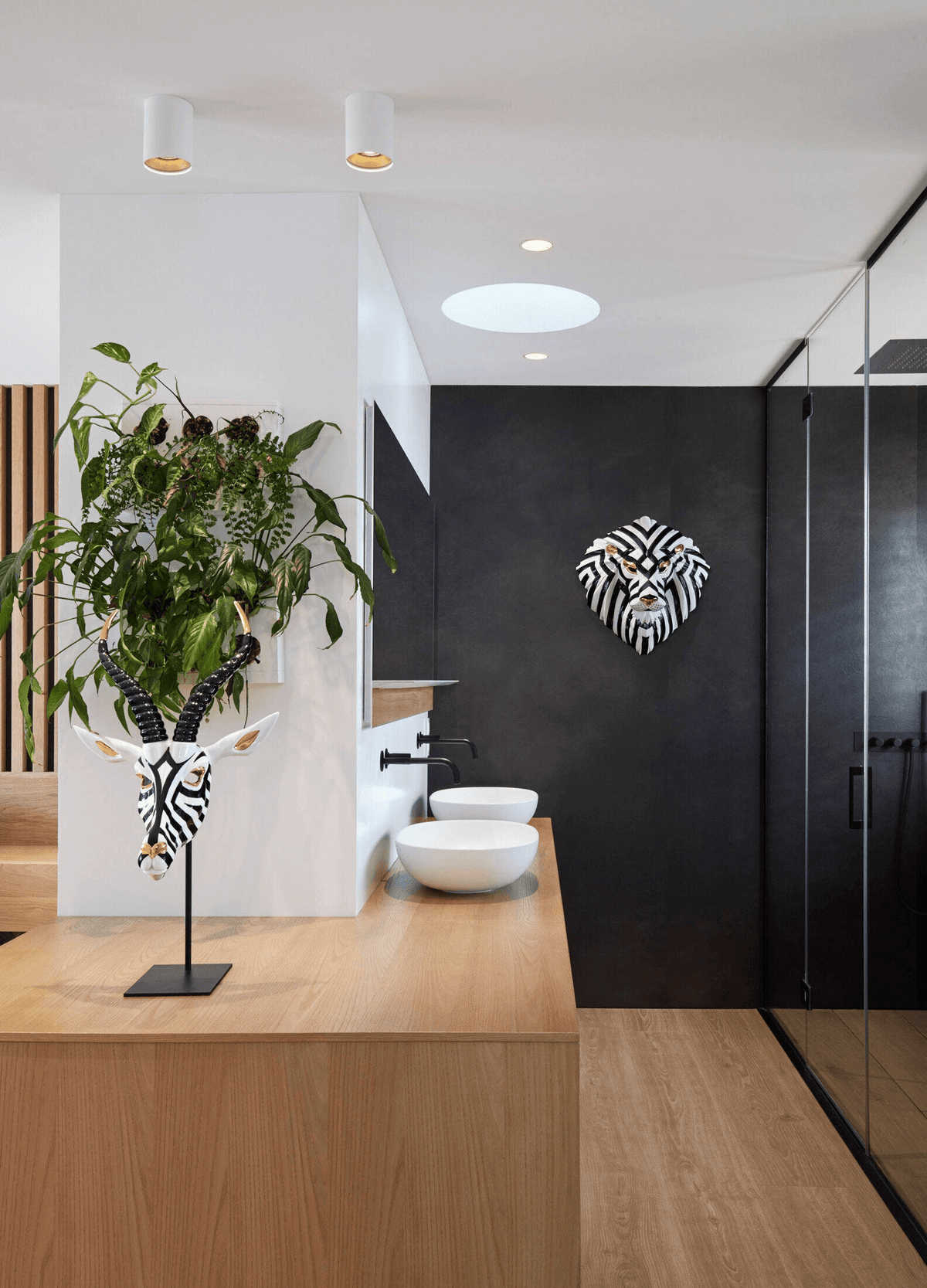 Lladró - Lion Mask - Black-Gold displayed in a modern bathroom with elegant fixtures and decor.