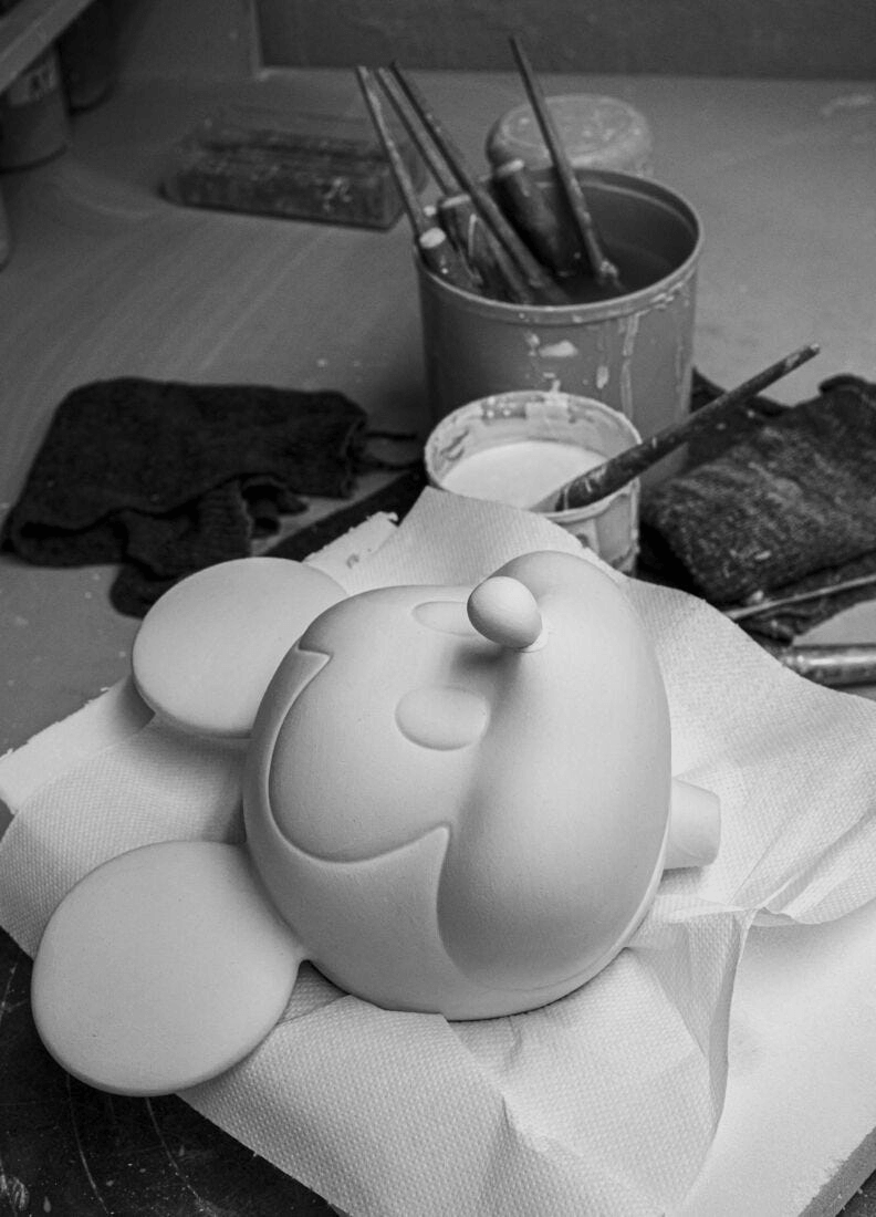 Lladró - Mickey Mouse Platinum Sculpture in progress, showcasing a raw porcelain figurine on a crafting table.