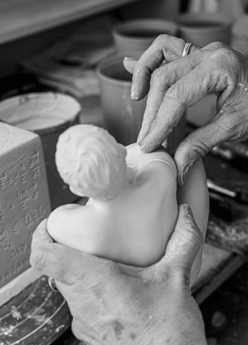 Craftsperson shaping a Lladró porcelain sculpture, highlighting artistry and attention to detail.