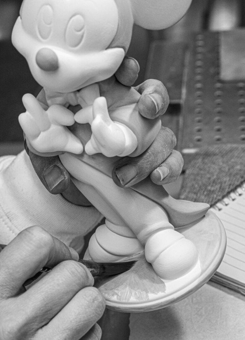 Lladró - Mickey Mouse Figurine being crafted in porcelain by skilled hands.