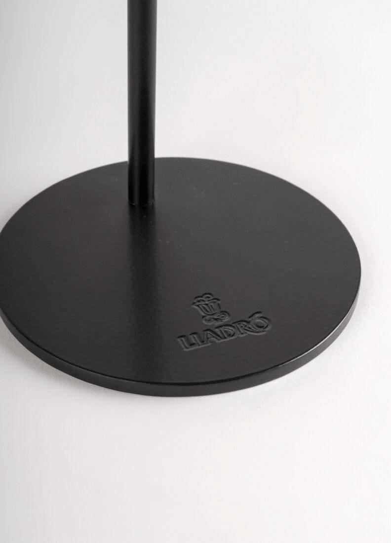 Lladró logo on the black base of a decorative figurine stand.