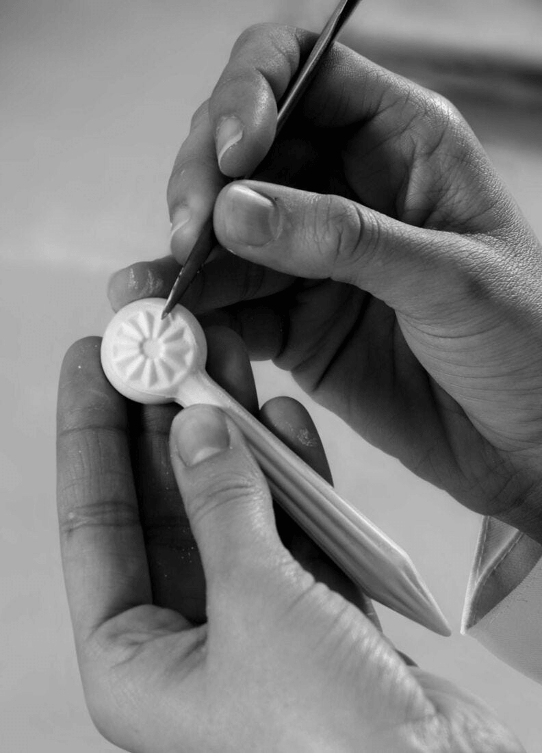 Artisan hand detailing a porcelain piece, showcasing the craftsmanship behind Lladró creations.