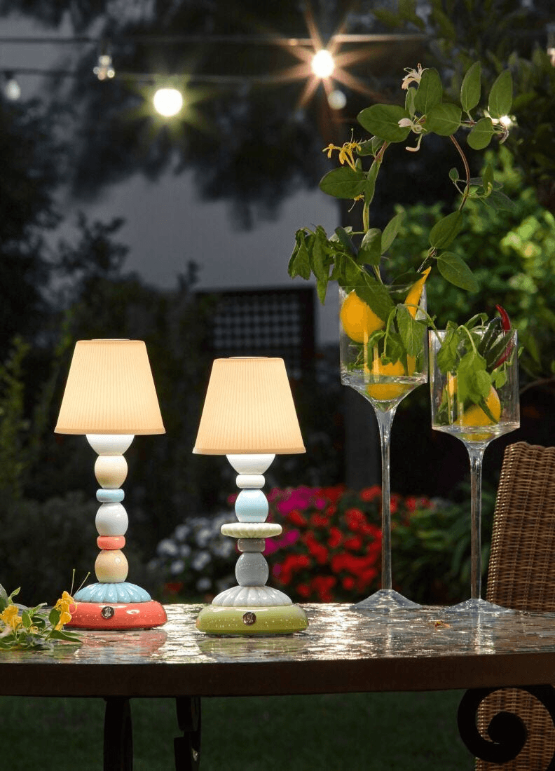 Lladró - Cactus Firefly Table Lamp - Red and Gold showcased outdoors with vibrant decorations and soft lighting.