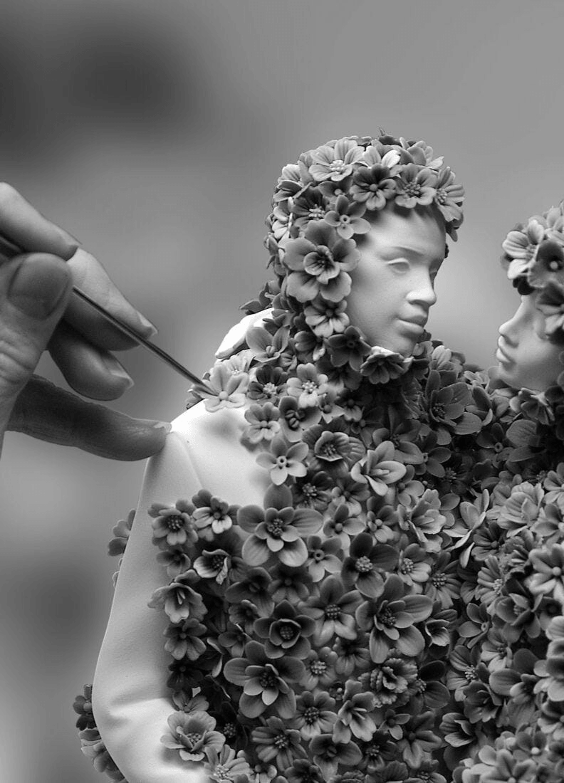 Lladró - Love III (blossoms) Sculpture being crafted, surrounded by intricate porcelain flowers.