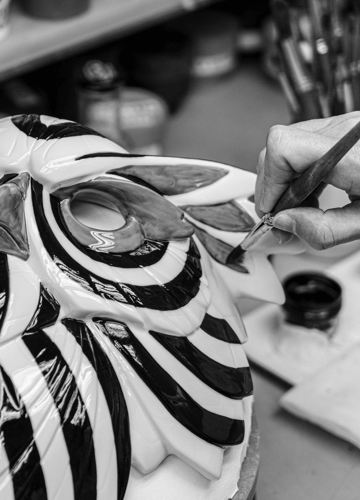 Artisan painting the Lladró - Lion Mask - Black-Gold, showcasing elegant porcelain craftsmanship.