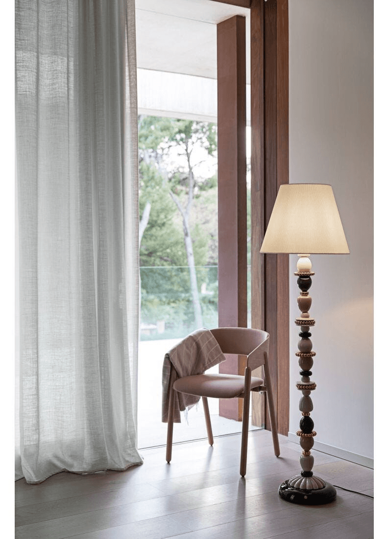 Lladró - Firefly Floor Lamp - Pink and Gold made of Lladro Porcelain, next to a pink chair.
