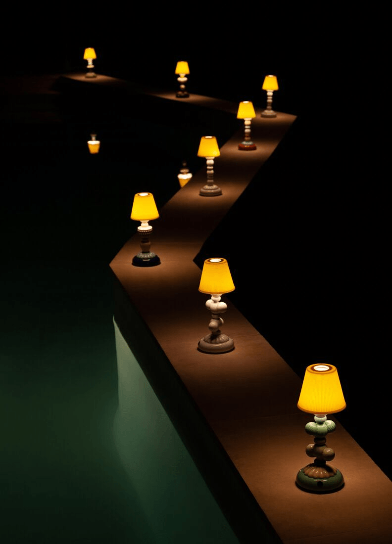 Lladró - Cactus Firefly Table Lamp - Red and Gold displayed along a poolside pathway at night.