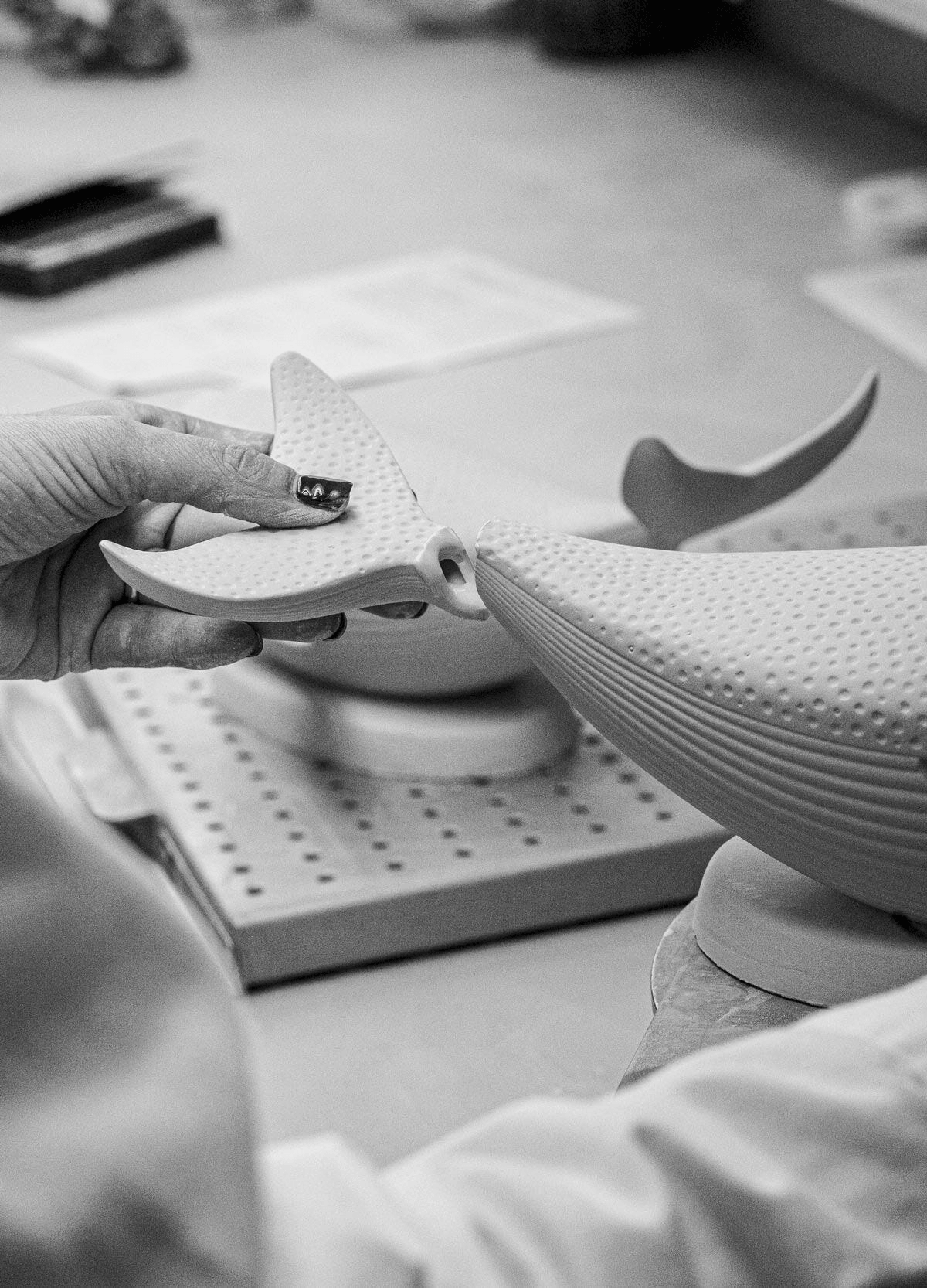 Lladró - Whale porcelain piece being carefully assembled by hand in a workshop setting.