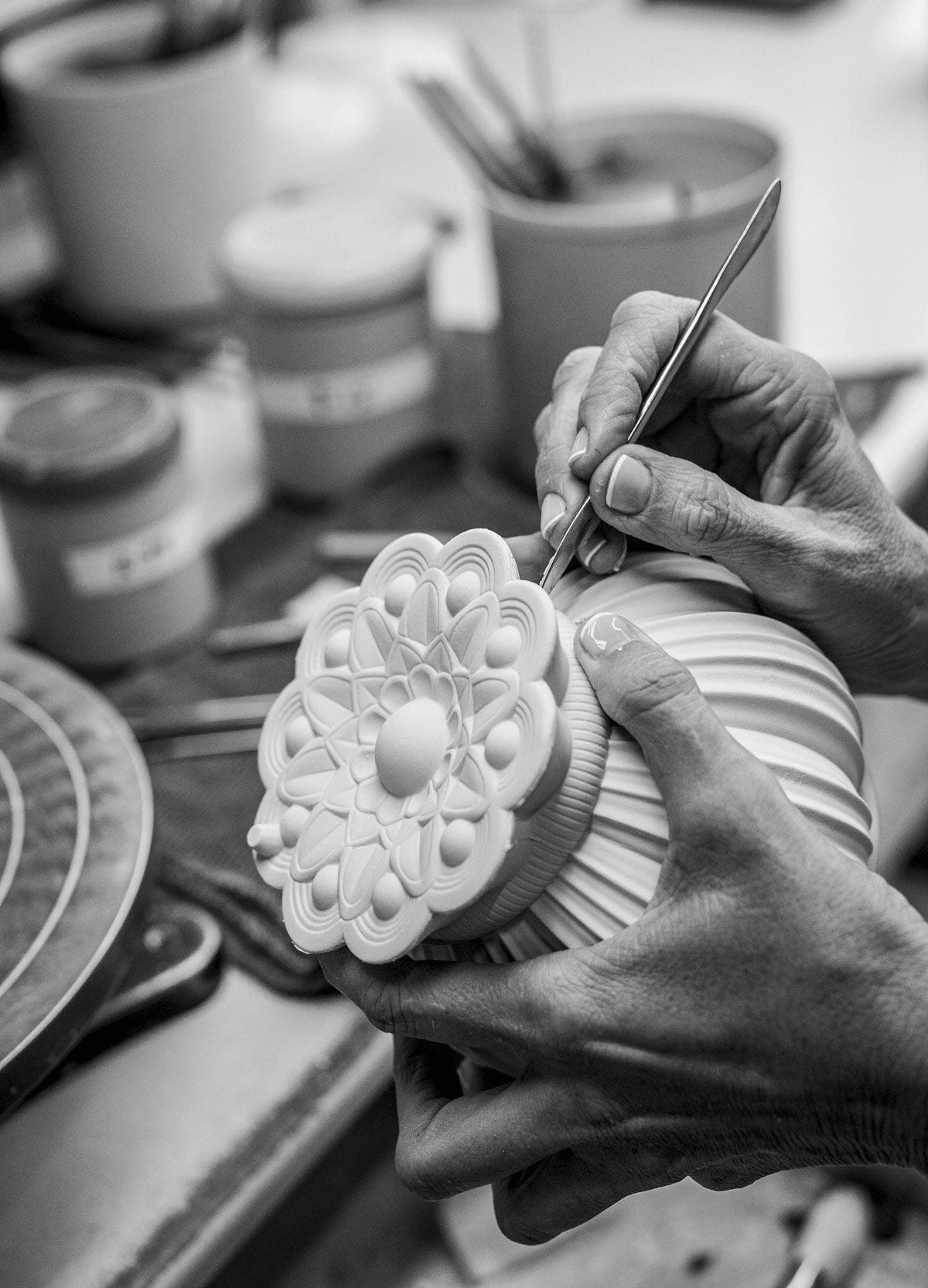 Craftsman sculpting a porcelain piece for Lladró - Utopical Wireless Table Lamp, showcasing intricate design techniques.