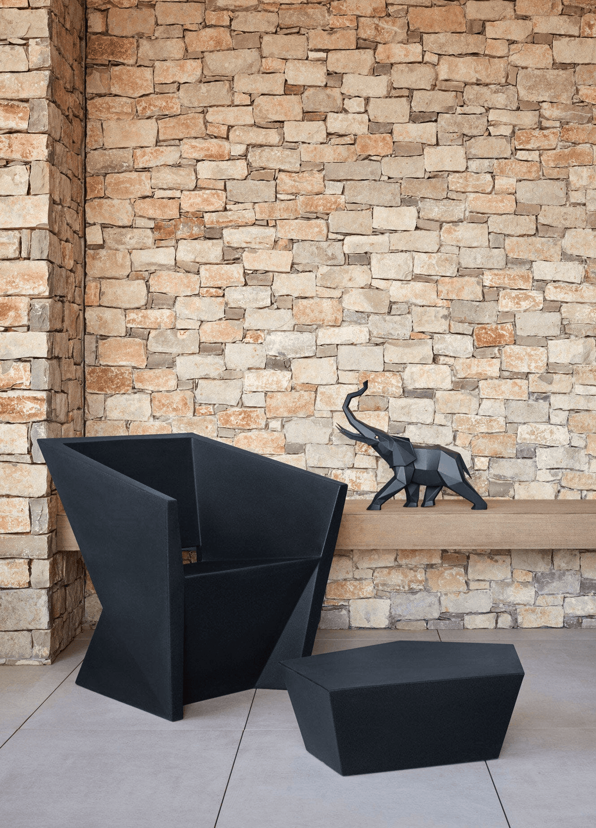 Lladró - Elephant Sculpture - Black matte on wooden shelf beside modern black chairs.