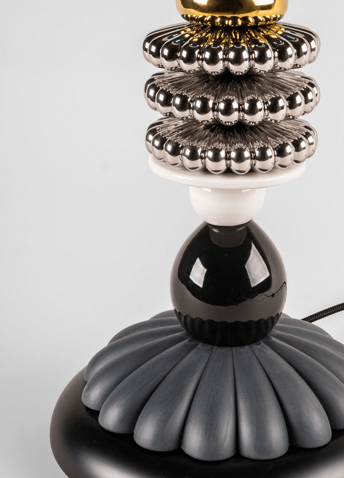 Base detail of the porcelain Lladró - Firefly Table Lamp by Olga Hanono, featuring metallic and black Lladro finish.