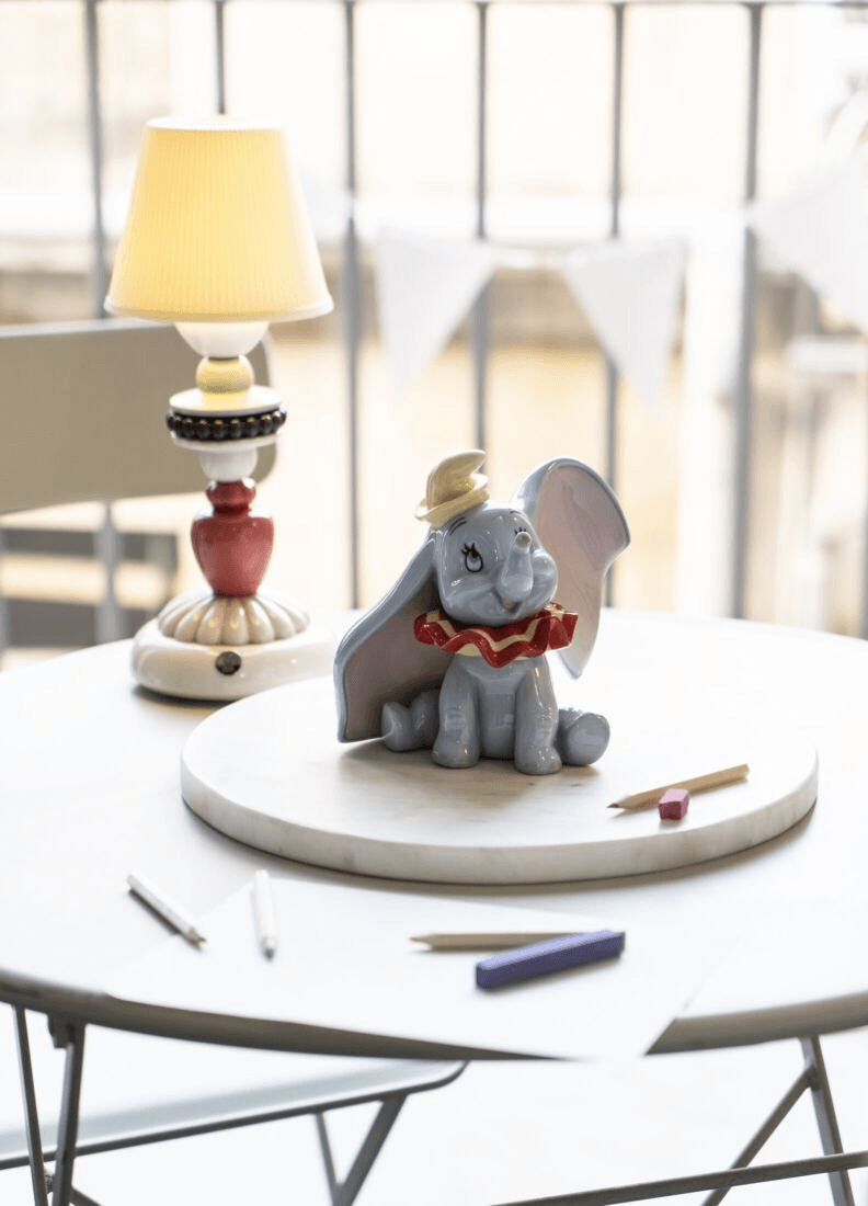 Lladró - Dumbo Figurine crafted in porcelain, showcasing Dumbo on a table with art supplies.
